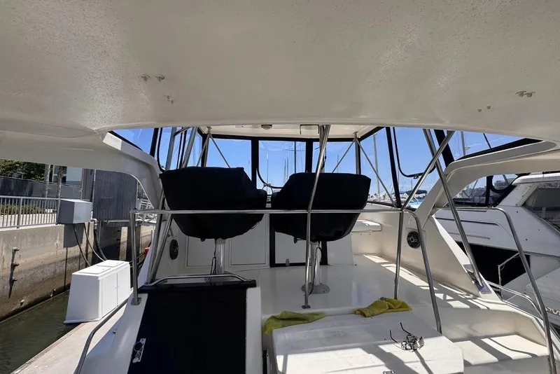 Slide: The Image of 1982 Sunliner Ocean Yachts interior with helm chairs and marina view. - 10