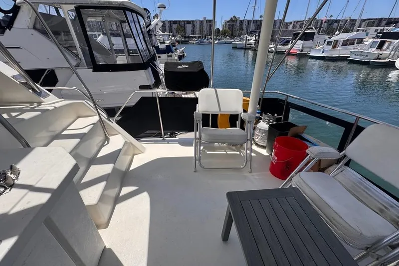 Slide: The Image of 1982 Sunliner Ocean Yachts deck with chairs, table, and marina view. - 11