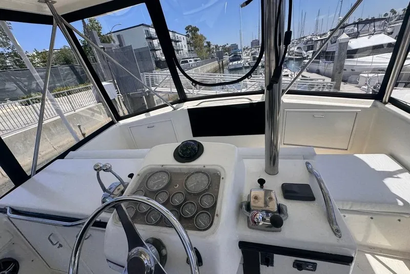 Slide: The Image of Interior view of 1982 Sunliner Ocean Yachts helm with gauges and controls, docked at marina. - 13