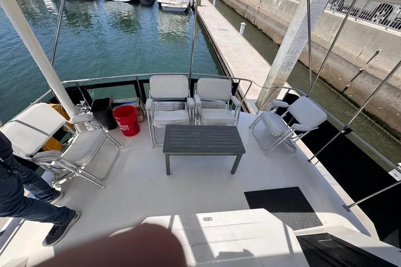 Slide: The Image of 1982 Sunliner Ocean Yachts deck with chairs and table, docked at marina. - 25