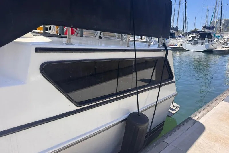 Slide: The Image of 1982 Sunliner Ocean Yachts boat docked in a marina, surrounded by water and other vessels. - 27