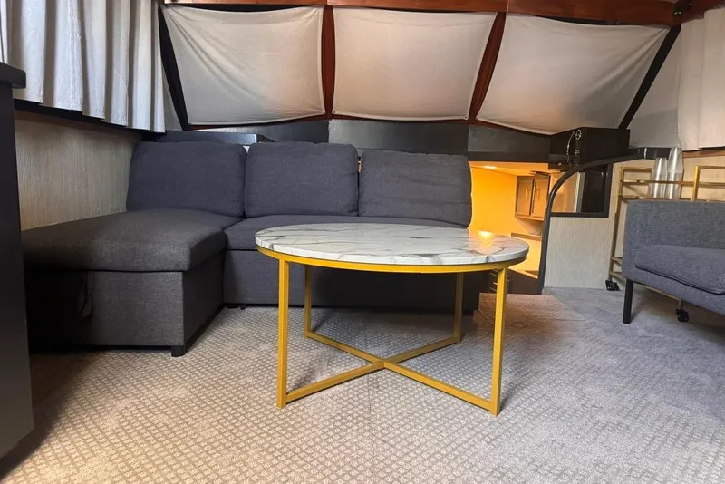Slide: The Image of Interior of 1982 Sunliner Ocean Yachts with modern gray sofa and round marble table. - 32
