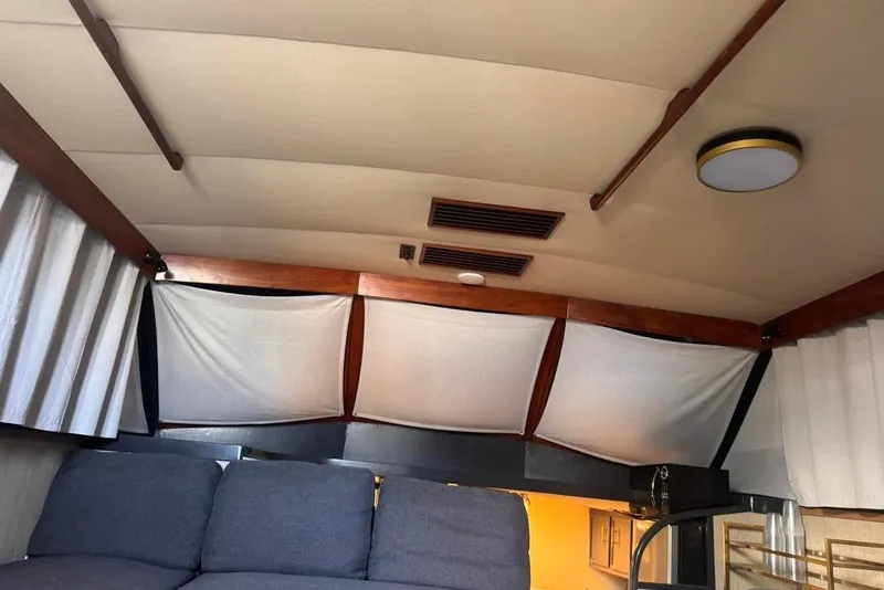 Slide: The Image of Interior of a 1982 Sunliner Ocean Yachts with curtains and a cozy seating area. - 34