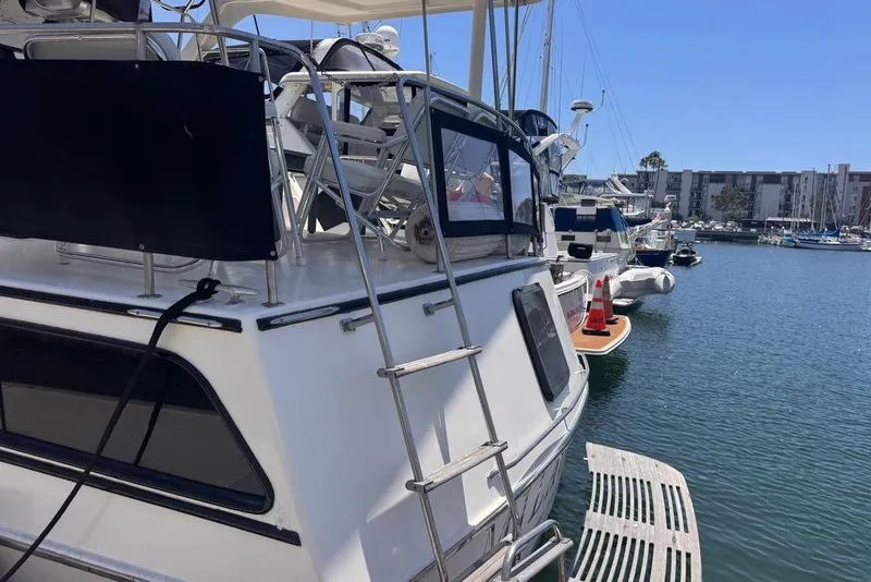 Slide: The Image of 1982 Sunliner Ocean Yachts docked at marina, featuring ladder and deck view. - 4