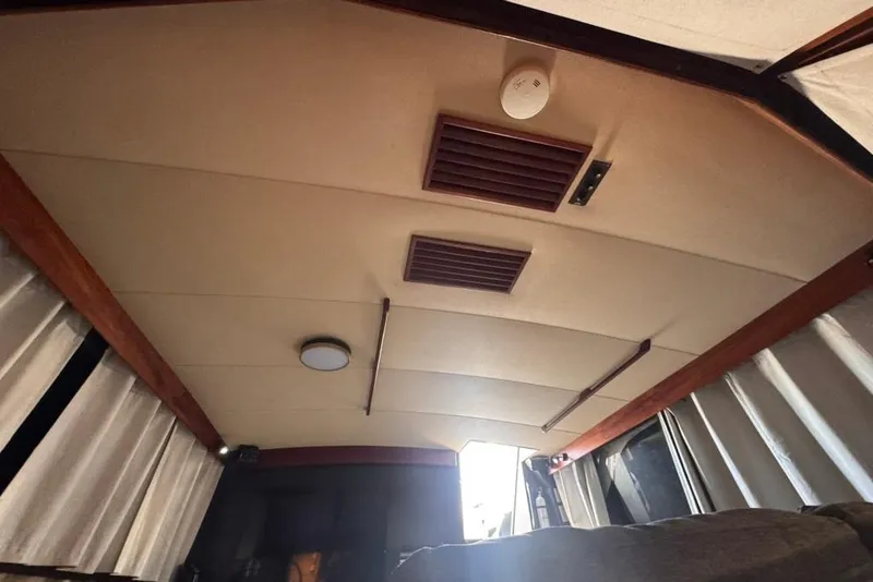 Slide: The Image of Interior ceiling of a 1982 Sunliner Ocean Yachts, featuring wood accents and curtains. - 47