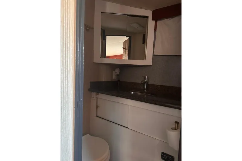 Slide: The Image of 1982 Sunliner Ocean Yachts bathroom with mirror, sink, and toilet. - 48
