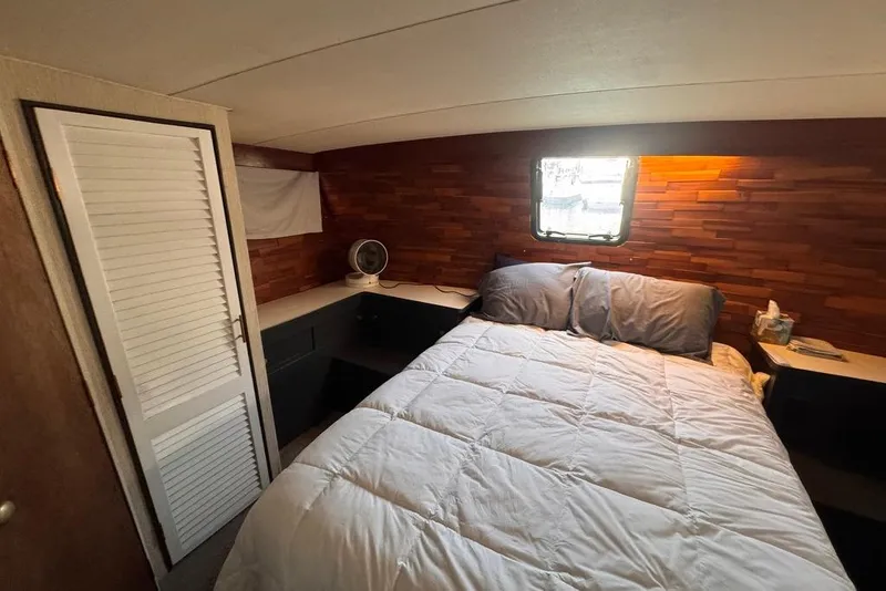Slide: The Image of Cozy bedroom in 1982 Sunliner Ocean Yachts with wood paneling and a small window. - 52
