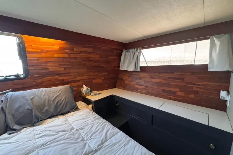 Slide: The Image of Cozy 1982 Sunliner Ocean Yachts cabin with wood paneling and comfortable bedding. - 56