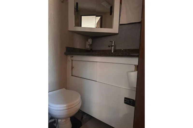 Slide: The Image of Compact bathroom in 1982 Sunliner Ocean Yachts, featuring a toilet and modern sink. - 58