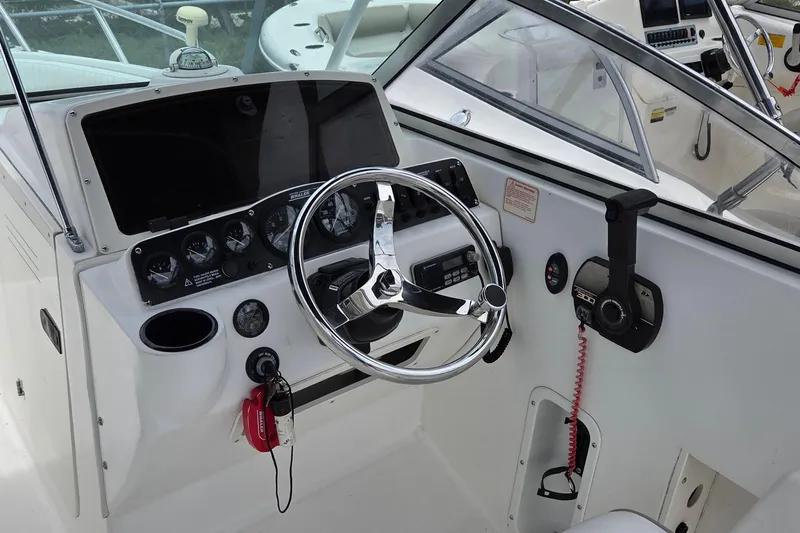 Slide: The Image of Cockpit of a 2000 Boston Whaler 21 Ventura boat, featuring steering wheel and control panel. - 9