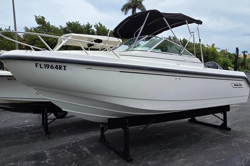 Slide: The Image of 2000 Boston Whaler 21 Ventura boat with canopy on display, parked on a stand. - 2