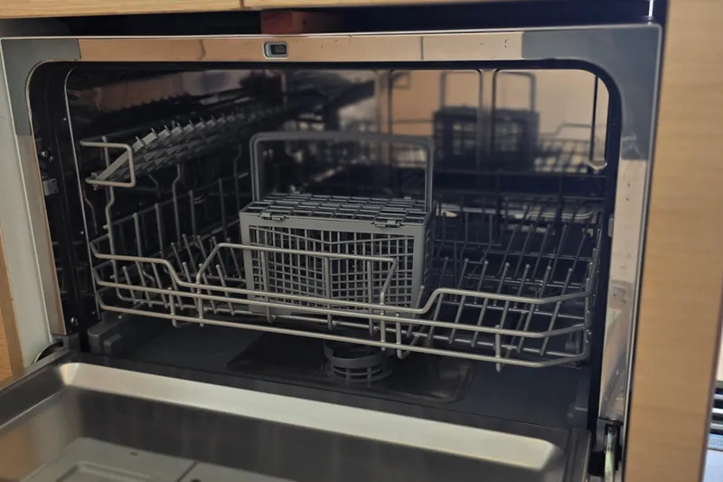 Slide: The Image of Open dishwasher inside a 2018 Fountaine Pajot Motor Yacht 44, showcasing racks and cutlery basket. - 28