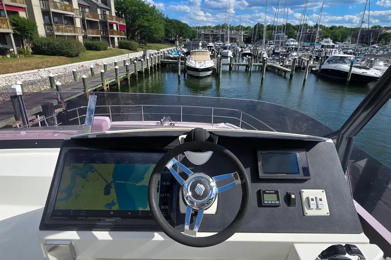 Slide: The Image of Helm of 2018 Fountaine Pajot Motor Yacht 44 overlooking marina with docked boats. - 76
