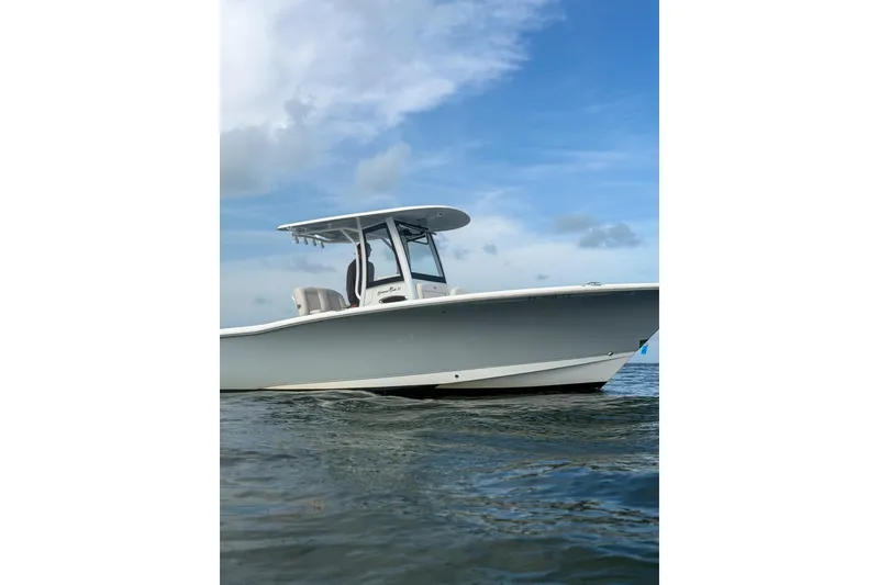 Slide: The Image of 2024 Sea Hunt Gamefish 27 boat on water under blue sky. - 10