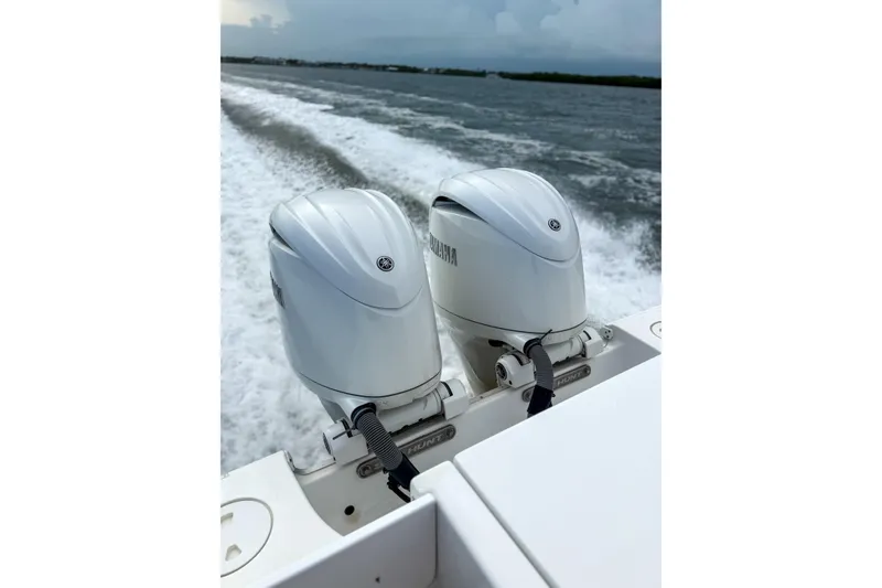 Slide: The Image of 2024 Sea Hunt Gamefish 27 boat with dual Yamaha outboard motors on water. - 12