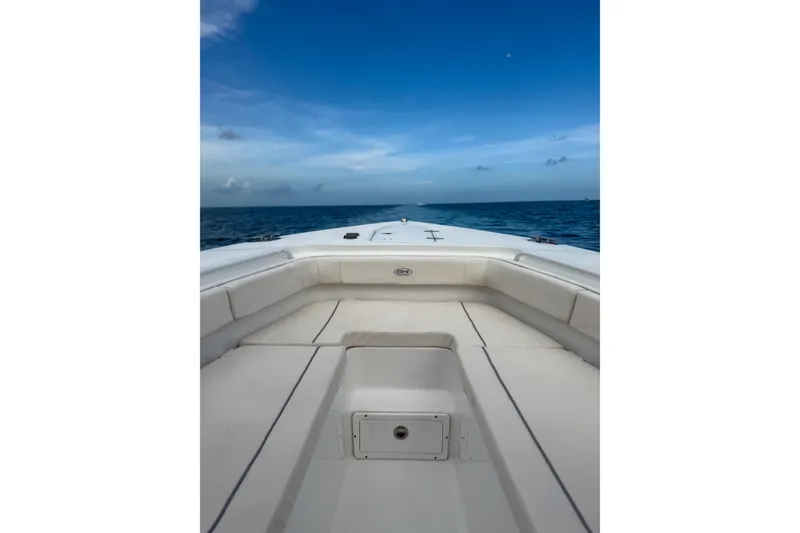Slide: The Image of 2024 Sea Hunt Gamefish 27 Forward Seating boat on open ocean under clear blue sky. - 15