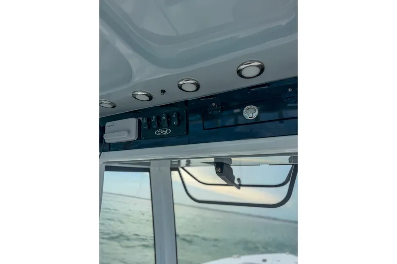 Slide: The Image of 2024 Sea Hunt Gamefish 27 boat interior with control panel and ocean view. - 21