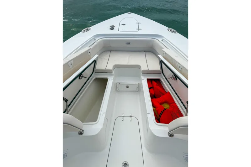 Slide: The Image of 2024 Sea Hunt Gamefish 27 Forward Seating with open storage compartments and life jackets. - 24