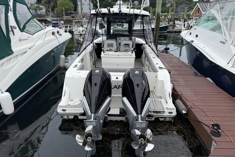 Slide: The Image of 2024 Boston Whaler 280 Outrage docked, featuring dual outboard engines. - 3