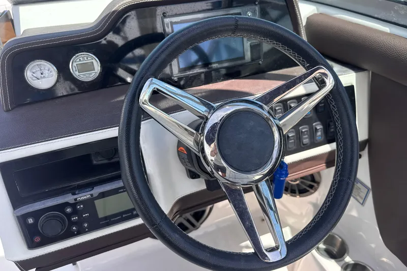 Slide: The Image of Steering wheel and dashboard of 2018 Regal 26 OBX boat, featuring modern controls and gauges. - 13