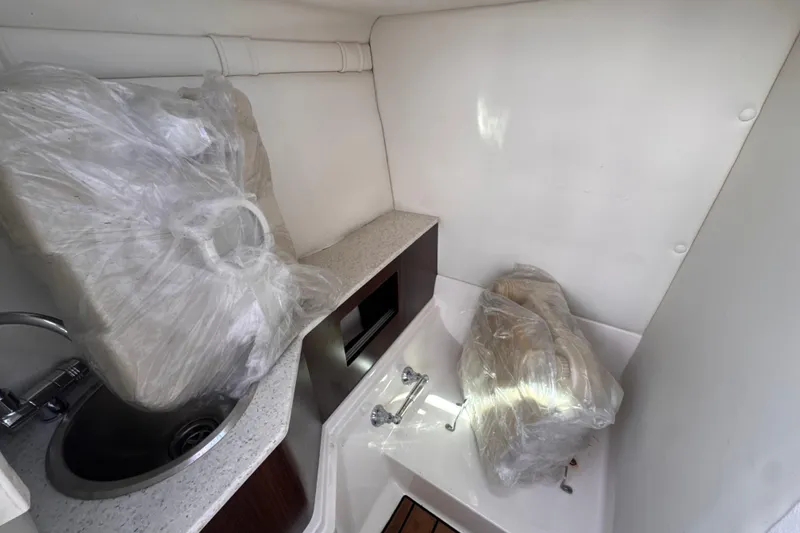 Slide: The Image of 2018 Regal 26 OBX boat interior with sink and wrapped cushions. - 17
