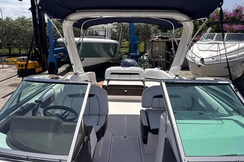 Slide: The Image of 2018 Regal 26 OBX boat interior with seating and steering wheel, docked at marina. - 19