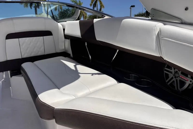 Slide: The Image of 2018 Regal 26 OBX boat interior with white and black seating, cup holders, and speaker. - 20