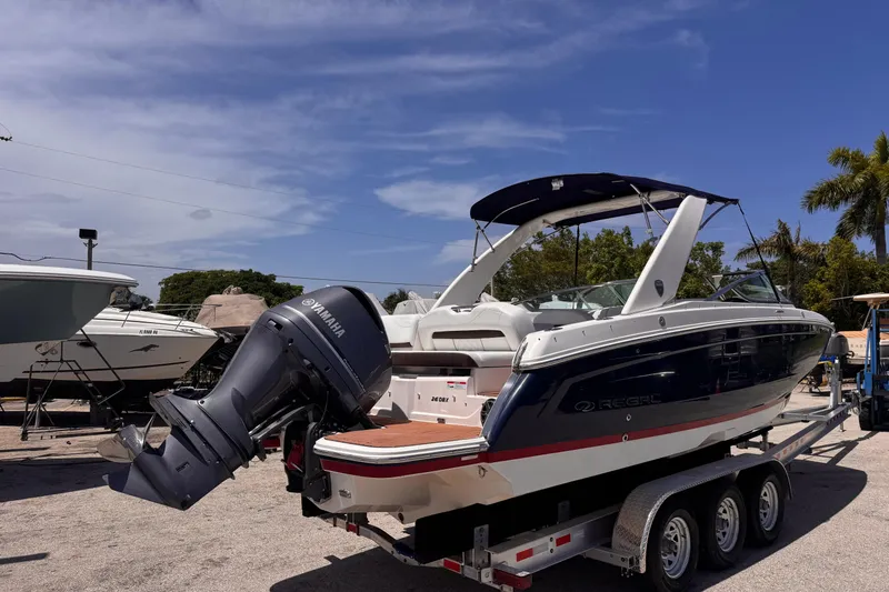 Slide: The Image of 2018 Regal 26 OBX boat with Yamaha outboard motor on a trailer, under clear skies. - 4