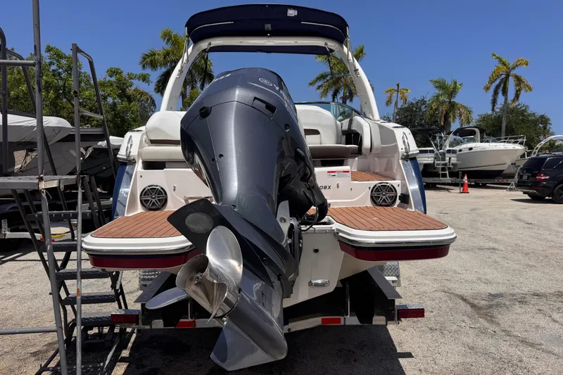Slide: The Image of 2018 Regal 26 OBX boat with outboard motor, parked on a sunny day. - 8