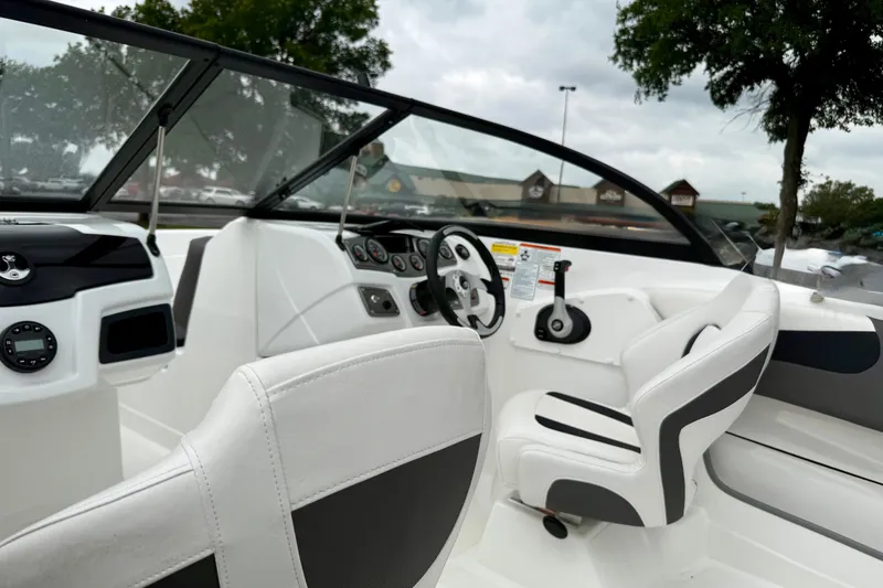 Slide: The Image of 2024 Tahoe 200 S boat interior with steering wheel and white seating. - 9