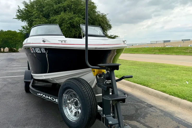 Slide: The Image of 2024 Tahoe 200 S boat on trailer in parking lot, overcast sky. - 2