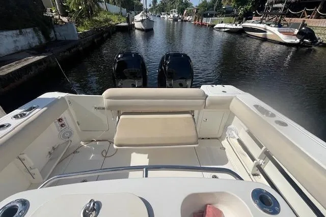 Slide: The Image of 2016 Boston Whaler 270 Dauntless boat interior with dual engines on a scenic canal. - 23