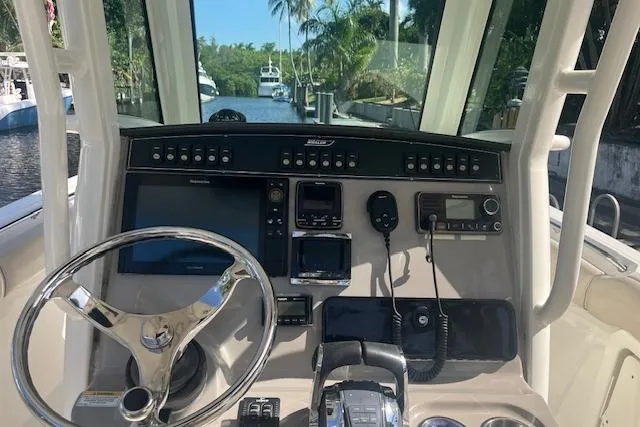 Slide: The Image of Control panel of a 2016 Boston Whaler 270 Dauntless boat with steering wheel and electronics. - 19