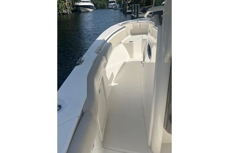 Slide: The Image of 2016 Boston Whaler 270 Dauntless boat deck, docked on a calm waterway. - 21