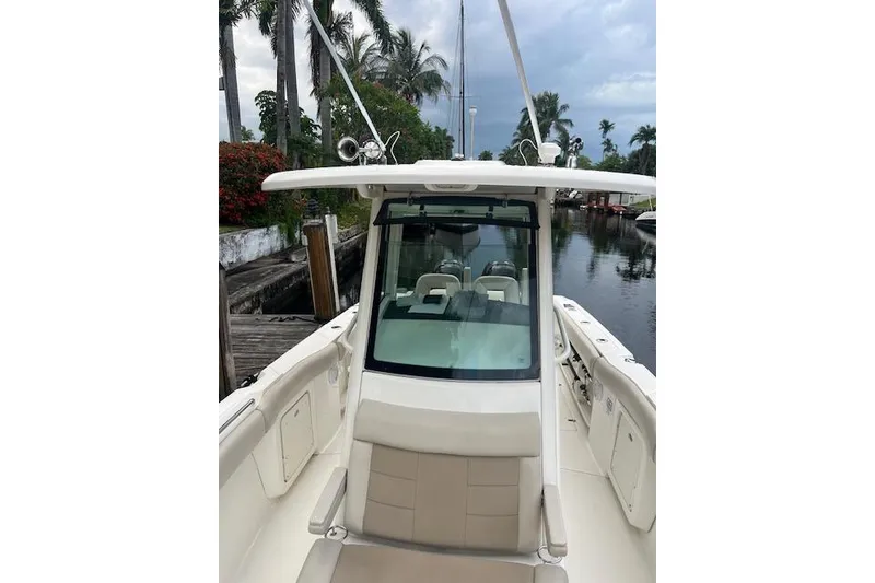 Slide: The Image of 2016 Boston Whaler 270 Dauntless boat docked by a scenic canal with palm trees. - 2