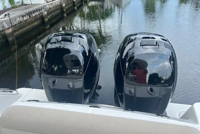 Slide: The Image of Twin outboard engines on a 2016 Boston Whaler 270 Dauntless, docked by a canal. - 12