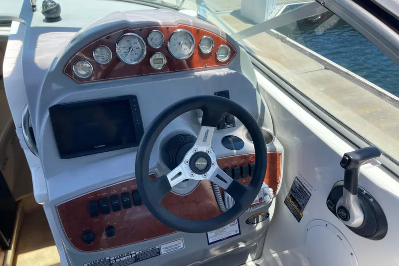 Slide: The Image of Cockpit of 2008 Bayliner 265 boat with steering wheel and control panel. - 10