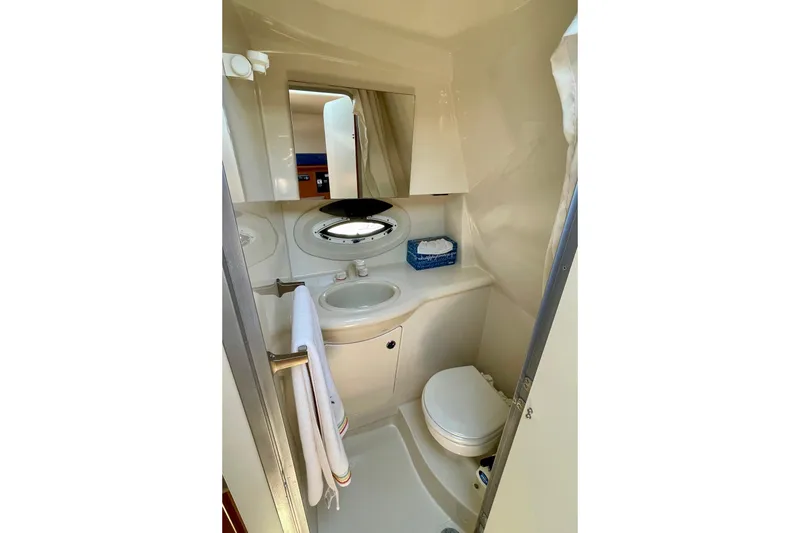 Slide: The Image of Compact bathroom in 2008 Bayliner 265 boat, featuring sink, toilet, and mirror. - 27