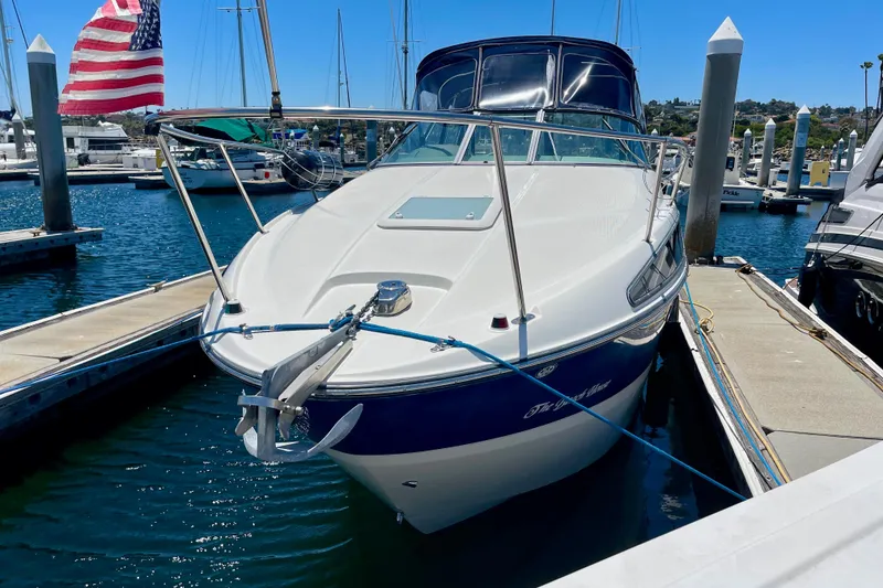 Slide: The Image of 2008 Bayliner 265 boat docked at marina with American flag, clear blue sky. - 3