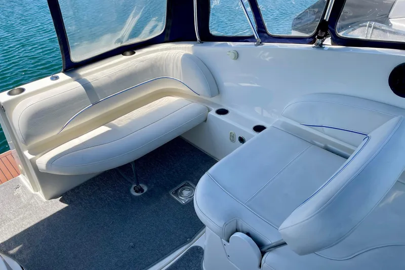 Slide: The Image of 2008 Bayliner 265 boat interior with white seating and blue accents. - 8