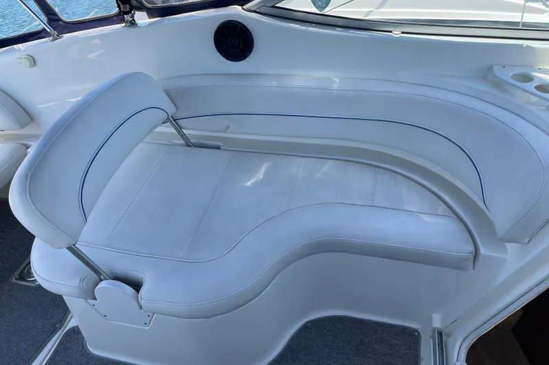 Slide: The Image of 2008 Bayliner 265 boat interior with white cushioned seating and cup holders. - 9