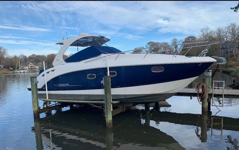 The Image of A 2013 Chaparral 330 Signature on a boat lift in a calm harbor. - 0