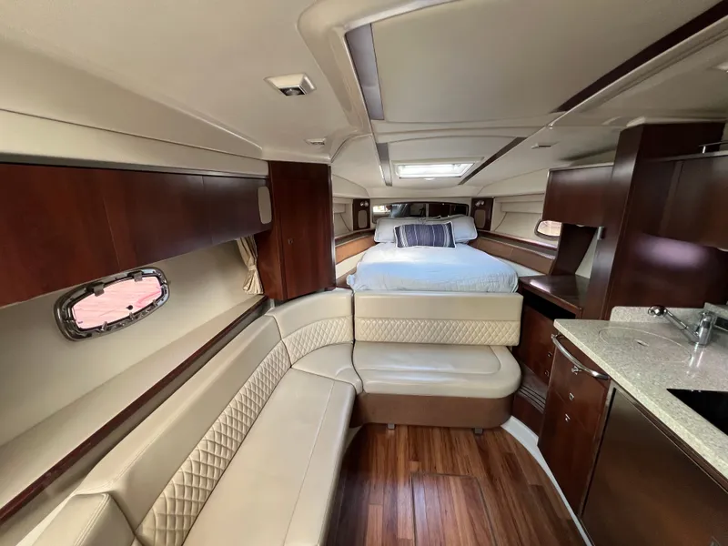 Slide: The Image of Interior of a 2013 Chaparral 330 Signature with elegant wood furnishings and a cozy bed. - 2