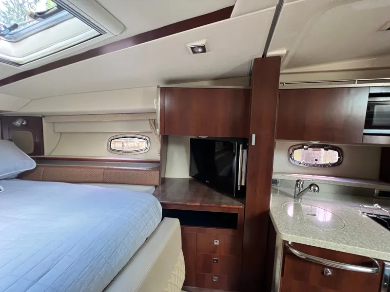 Slide: The Image of Interior of a 2013 Chaparral 330 Signature with bed, cabinets, and kitchenette. - 4