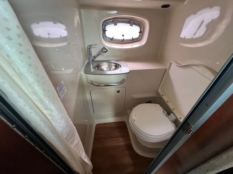 Slide: The Image of The image shows a boat bathroom with a sink, toilet, and porthole. - 7