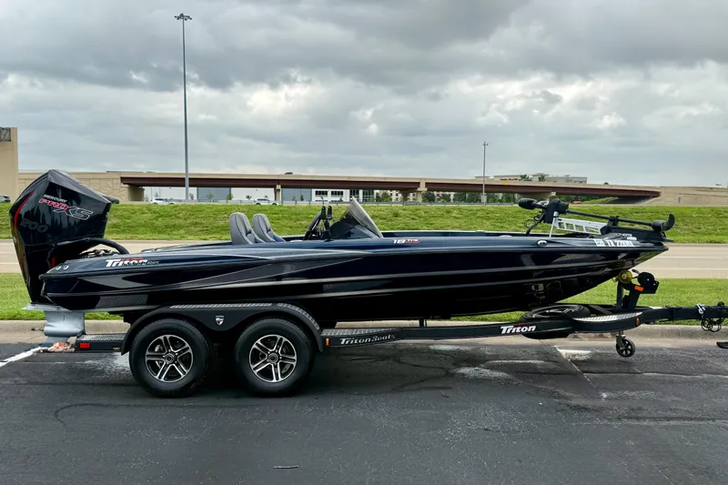 The Image of 2023 Triton 18 TrX boat on trailer, parked outdoors under cloudy sky. - 15