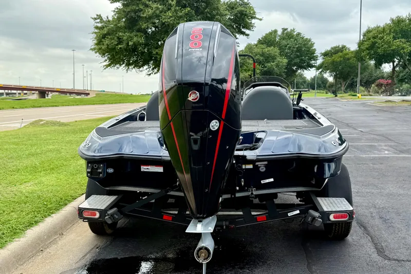 Slide: The Image of 2023 Triton 18 TrX boat with powerful outboard motor, parked on a paved road. - 19