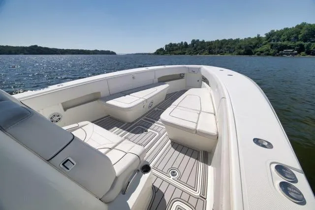 Slide: The Image of 2016 SeaVee 390 boat with spacious seating, cruising on a serene lake under clear skies. - 31