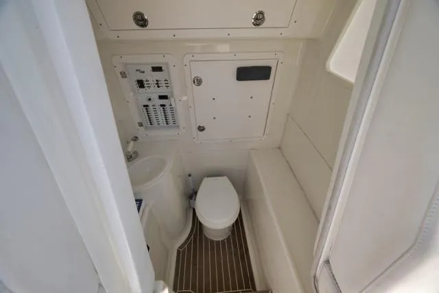 Slide: The Image of 2016 SeaVee 390 boat interior with compact bathroom, featuring toilet and control panel. - 44