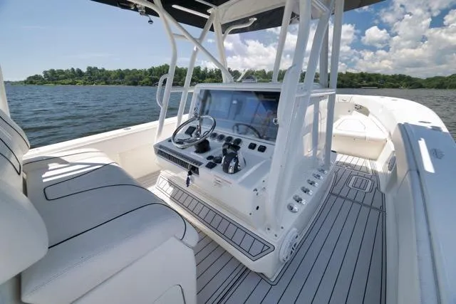 Slide: The Image of 2016 SeaVee 390 boat cockpit with steering wheel, controls, and seating on a sunny day. - 65